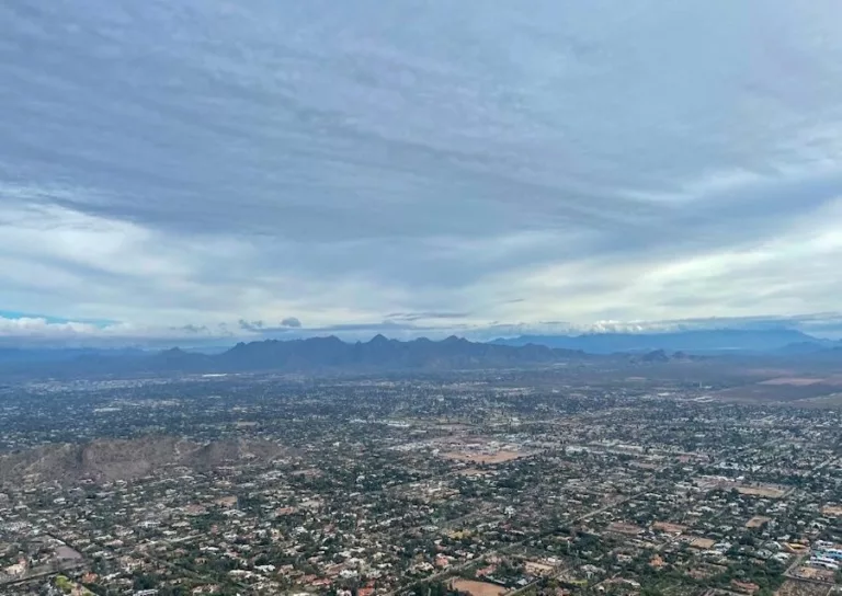 Deep blue sky with view of city and mountains in the distance.