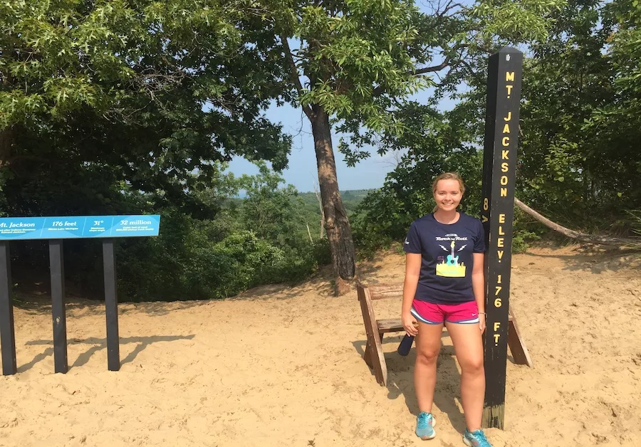 hiking vacation on a budget - young female adult in sand dunes 