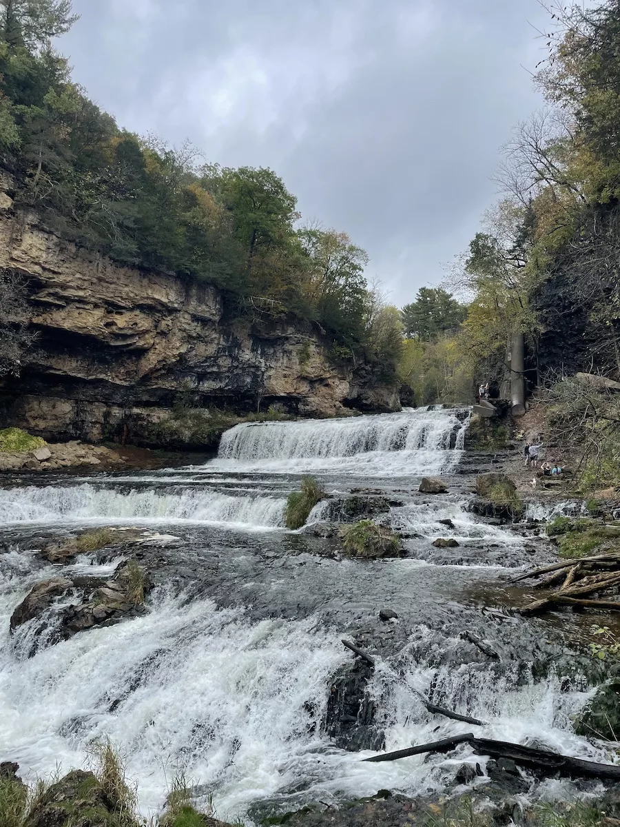 Waterfall surrounded by cliffs, trees in Wisconsin. 