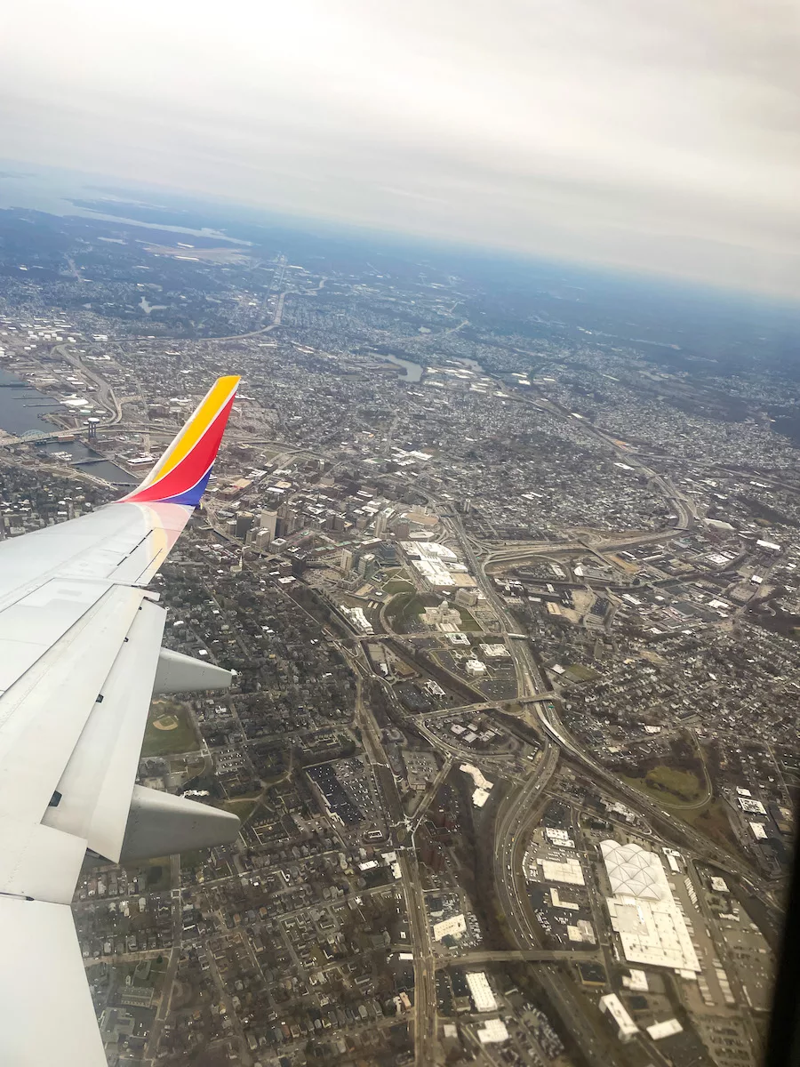 Travel Resources - Plane wing overlooking a city from the sky. 