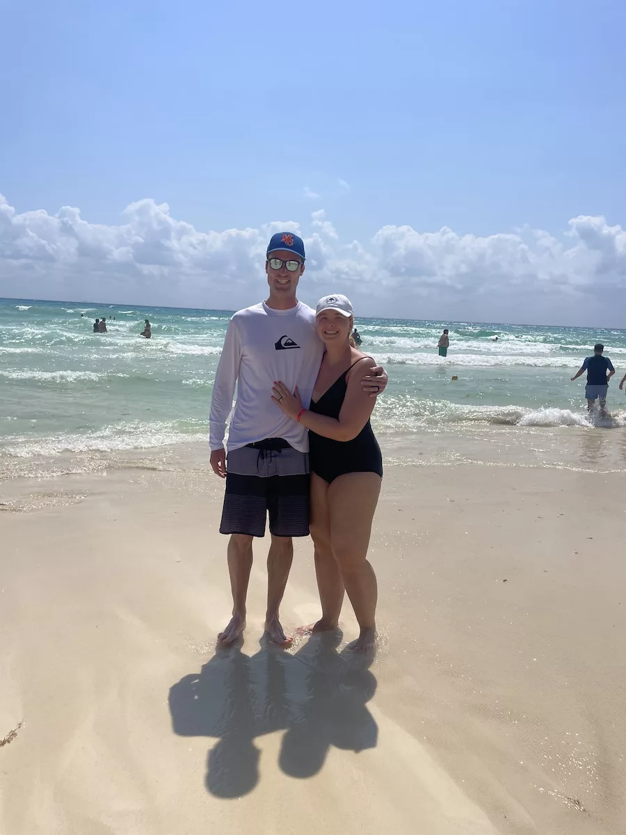 Passion for Travel - Husband and Wife on Beach with ocean in background. 