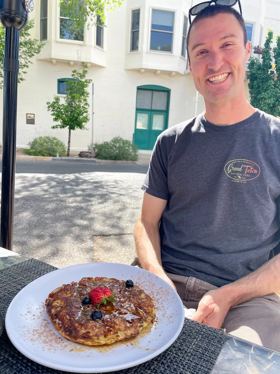 Man posing next to breakfast food at Lush Cafe in Albuquerque, New Mexico