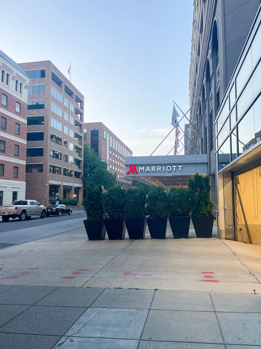 View of the Entrance sign to a Marriott Hotel surrounded by trees and numerous other buildings