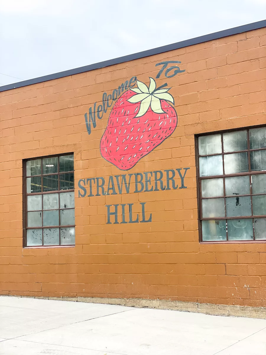 'Welcome to Strawberry Hill' mural with a strawberry painted on a brick building in Kansas City, Kansas 