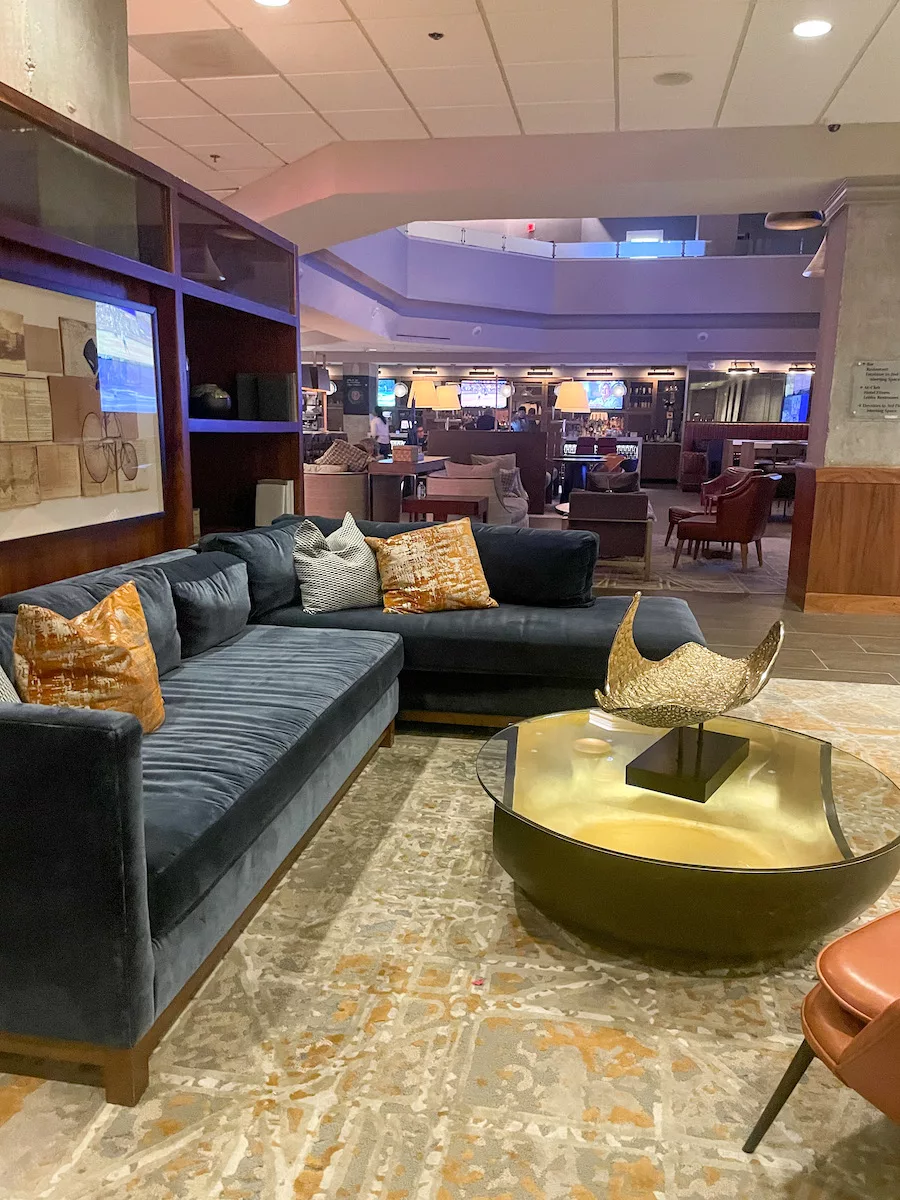 The lobby and bar area of the Washington Marriott Georgetown featuring comfy couches, chairs, tables and tvs. 