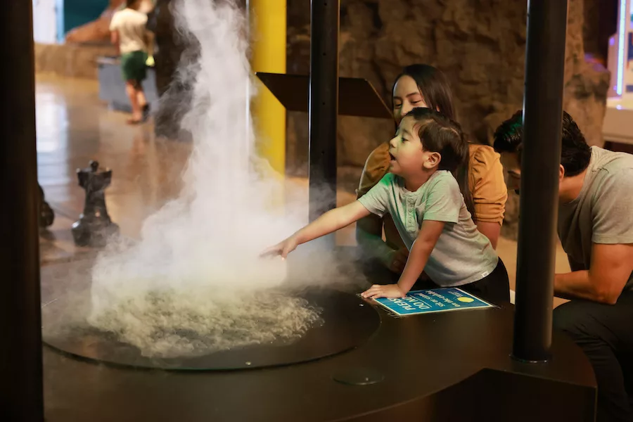 Little child exploring a science exhibit at the Discovery Center in Springfield, MO