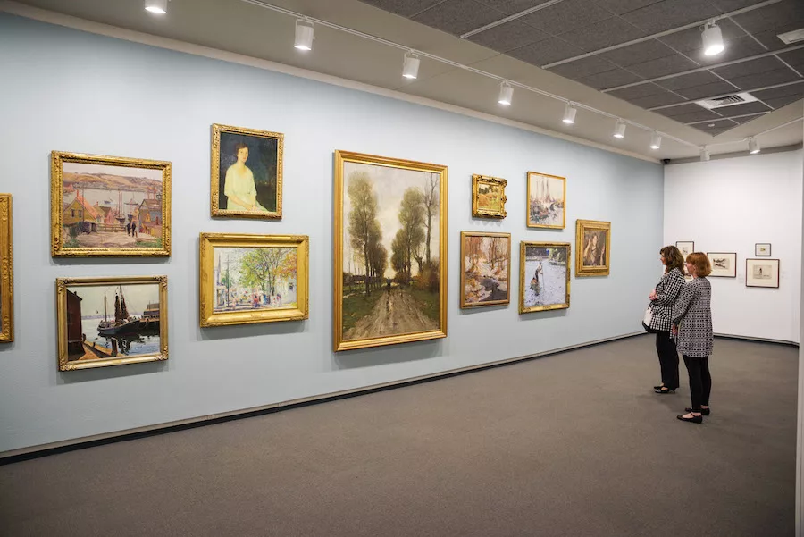 Two adults admiring a wall full of artwork at the Springfield Art Museum 