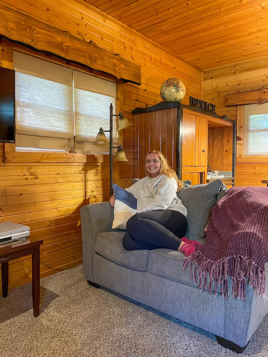 Young woman relaxing on a blue sofa next to a window. 