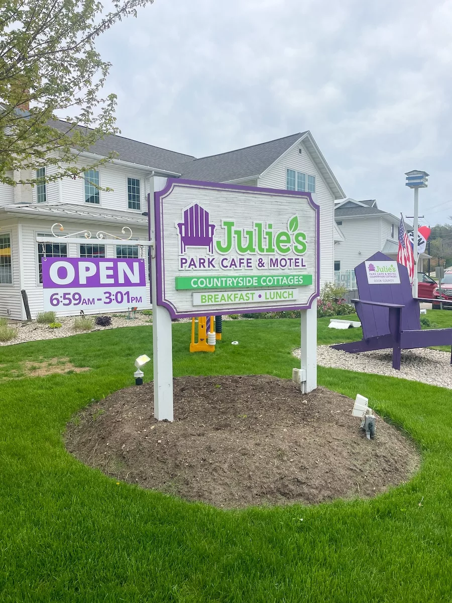 Image of Entrance Sign to Julie's Park Cafe and Motel in Fish Creek with large purple chair next to it