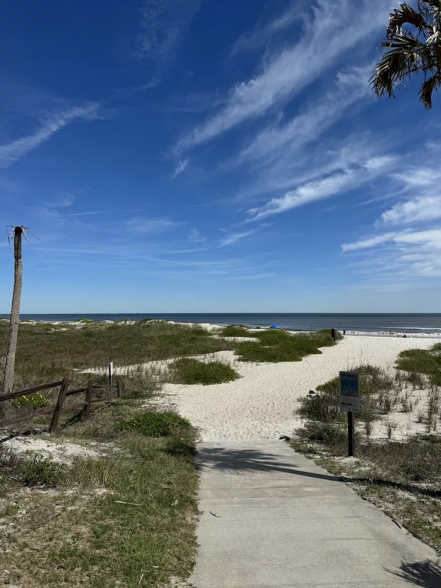 Beach walk at Kathryn Abbey Hanna Park - cloudy blue sky with sand dunes. 