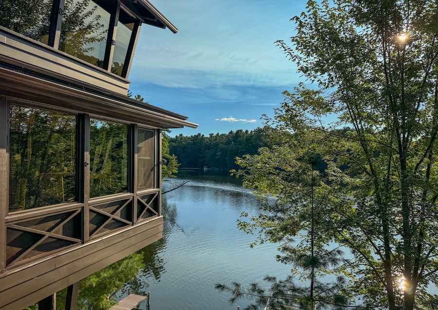 Image of Ishnala Supper Club with Mirror Lake in the background along with a blue sky and tall green trees.