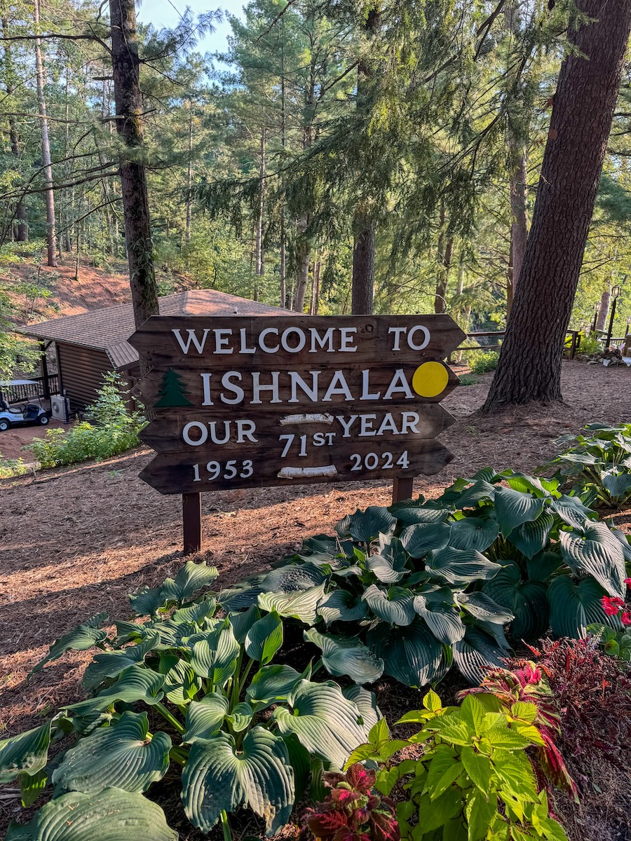 Image of the entrance sign to Ishnala Supper Club with bright plants and beautiful trees next to it - Wisconsin Dells, WI