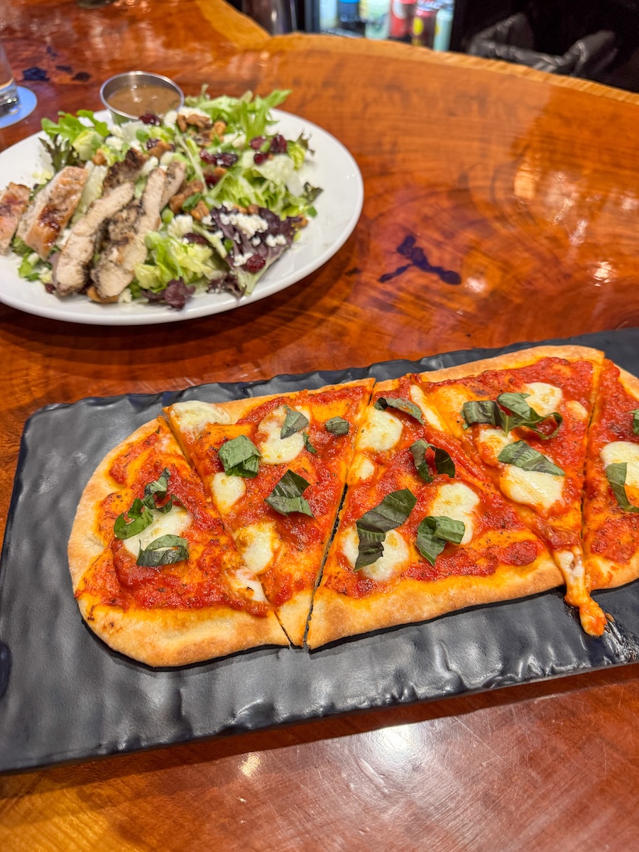 Image of margherita pizza and salad with chicken at Double V restaurant in Grand Island, Nebraska.