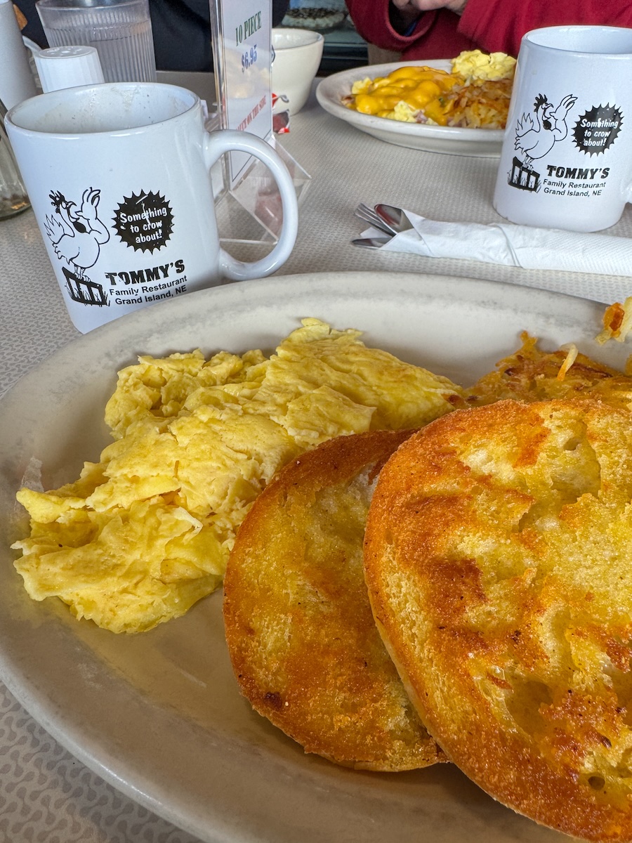 Image of a breakfast plate at a diner - eggs, english muffin, coffee cup.
